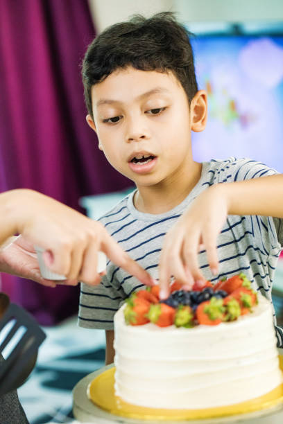 istock Muslim boy learning to decorate cake under his mother's direction 965015052