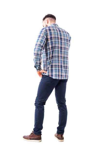 Profile back view of caucasian business man talking on the phone looking down with hand on hip Profile back view of caucasian business man talking on the phone looking down with hand on hip. Full body isolated on white background. worried man standing stock pictures, royalty-free photos & images
