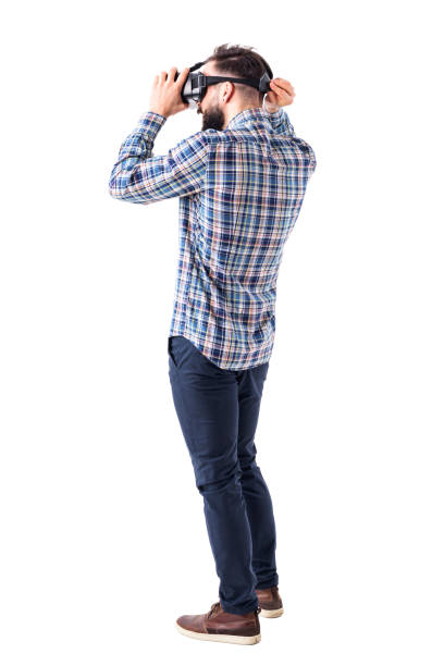 istock Young bearded smart casual man putting on virtual reality glasses headset on head. 965020276