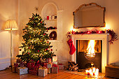 Christmas tree with gifts near fireplace