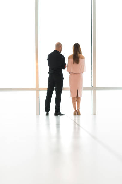 istock Business couple looking thru window from their office 965024680