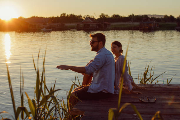 istock Young loving couple enjoys by the river during the sunset 965024718