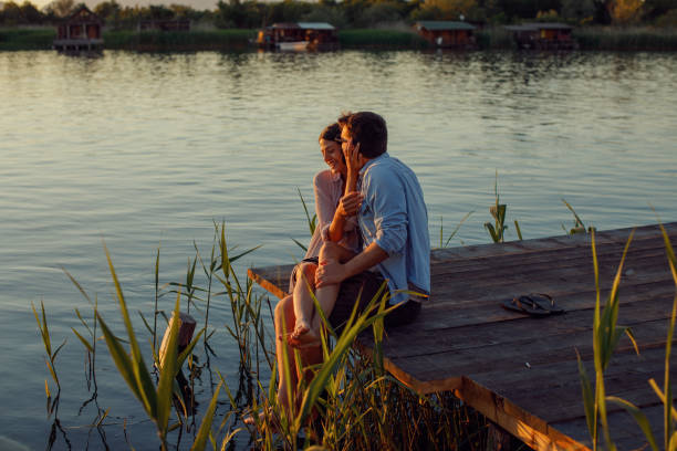 istock Young loving couple enjoys by the river during the sunset 965024734