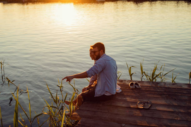 istock Young loving couple enjoys by the river during the sunset 965028200