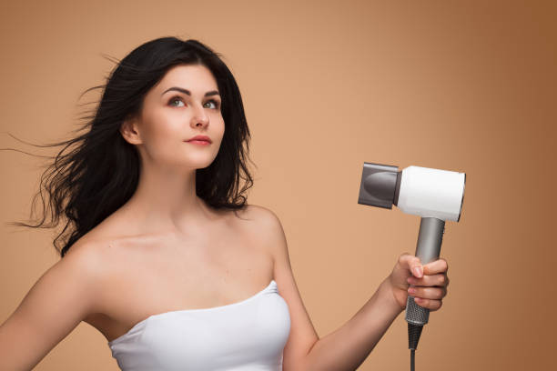 istock Beautiful woman using hair dryer 965048528