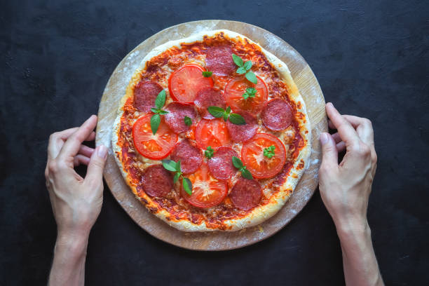 istock Home-made pepperoni pizza on a black table. 965063372