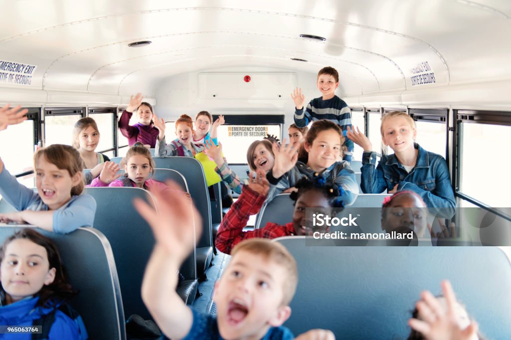 Students inside a school bus at the school's out Sweet little girls and boys inside de school bus at school's out. Multi-ethnic students in the bus. They seems happy because the school is finish. They all say goodbye. Photo was taken in Quebec Canada 10-11 Years Stock Photo
