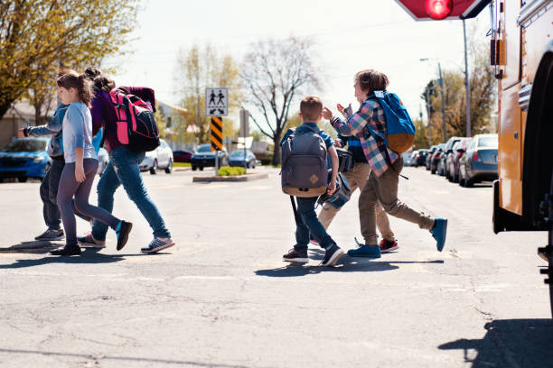 istock Group of elementary school kids getting out a school bus at school's out. 965072738