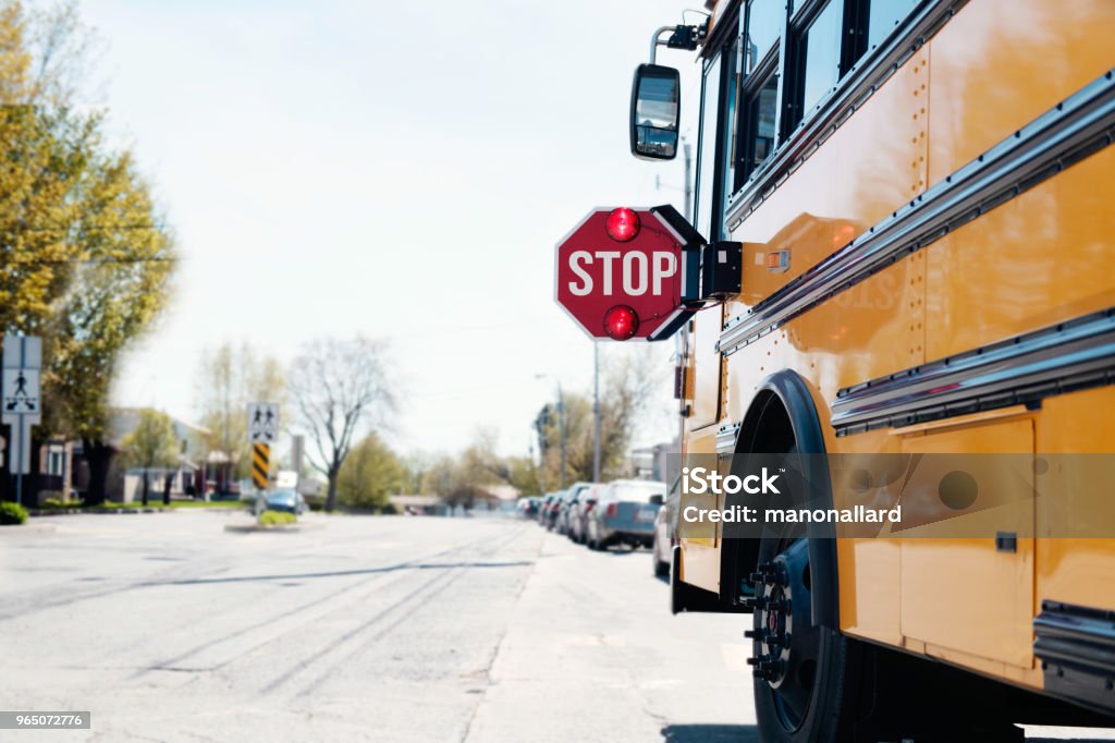 Yellow School bus with stop sign Yellow School bus with stop sigh in the street with red light open. Photo was taken in Canada. Back to School Stock Photo