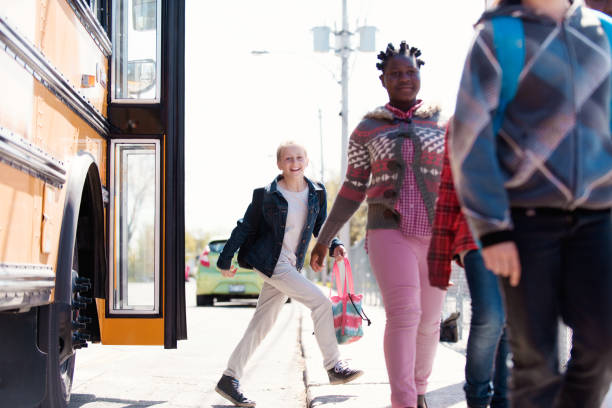 istock Group of elementary school kids getting out a school bus at school's out. 965073004
