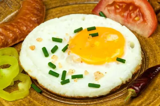 Fried egg for breakfast. Diet food. Food preparation. Fried egg on a wooden table