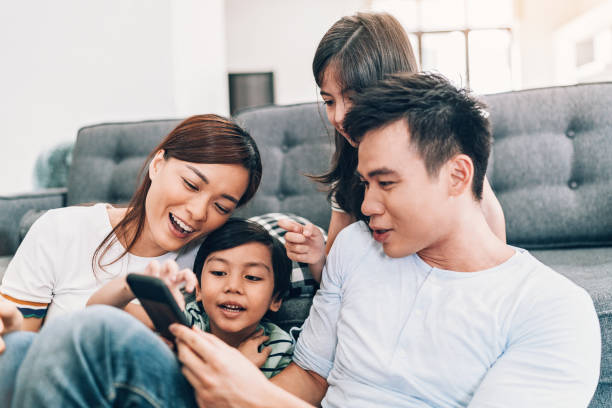 istock Smiling family with smart phone 965085716