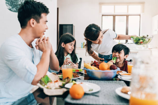 familia de etnia asiática feliz en la mesa - healthy eating fruit drink juice fotografías e imágenes de stock