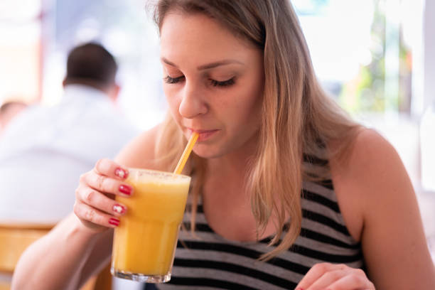 istock Woman drinking orange juice 965086326
