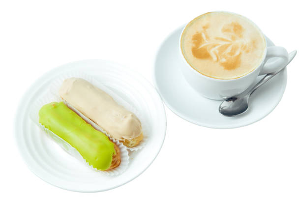 istock cup of cappuccino and two eclair isolated on white background 965086542