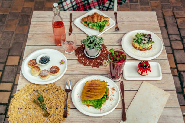 istock breakfast served cafe table with cheese pancakes, sandwich, croissant and drinks. Top view 965088886