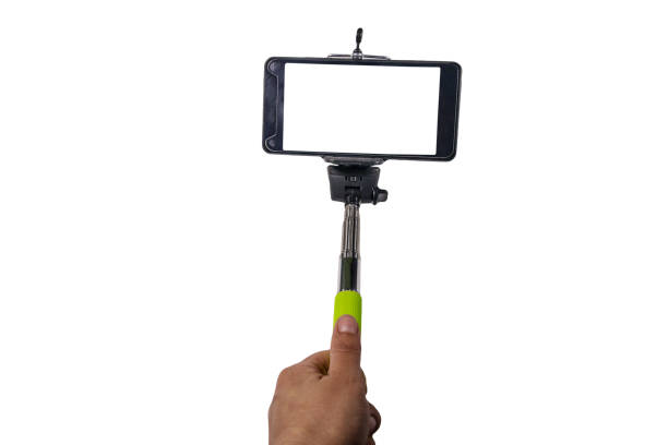 istock Human hand holding monopod for selfie with smartphone isolated on white background 965089996