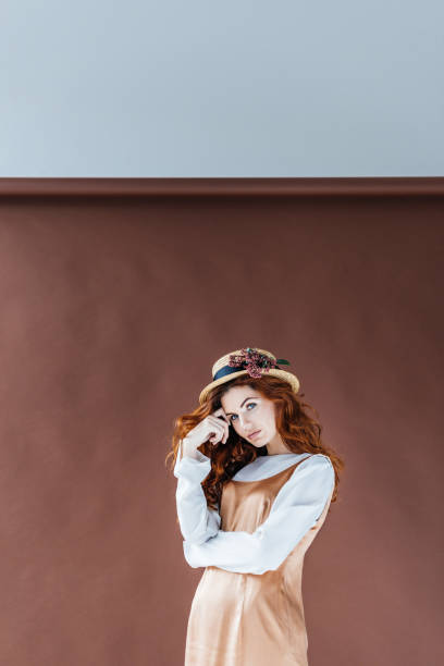 istock Attractive redhead woman wearing straw hat with flowers 965090130