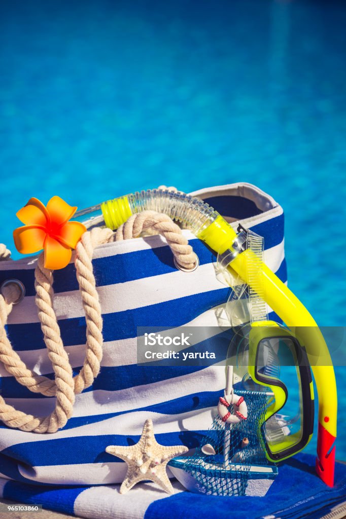 Summer vacation Blue striped beach bag against water background. Summer vacation concept Backgrounds Stock Photo