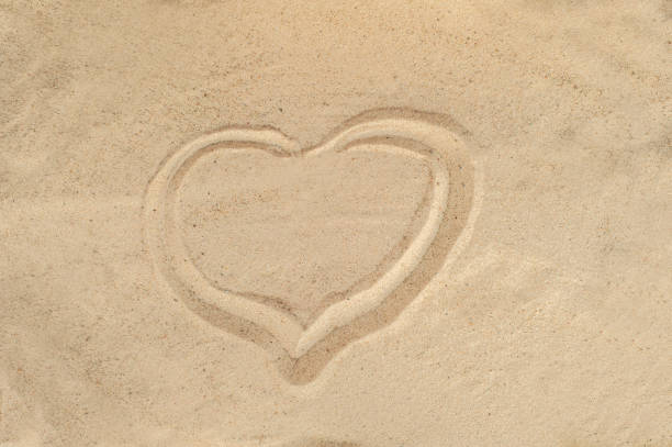istock Heart drawn in the sand. Beach background. Top view 965105266