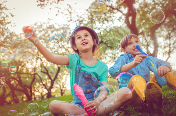 istock Happy children blowing bubbles in the park 965116764