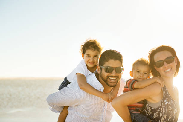 istock Beautiful family holding hands walking on the beach 965139498
