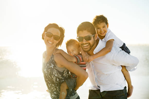 istock Beautiful family holding hands walking on the beach 965139502