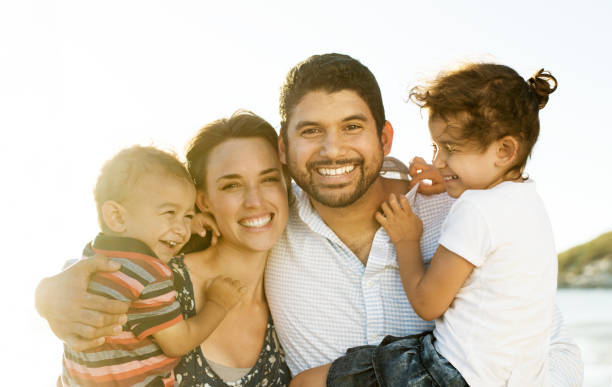 istock Beautiful family holding hands walking on the beach 965139816
