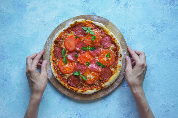 istock Homemade pepperoni pizza on a blue kitchen table. Top view 965150988
