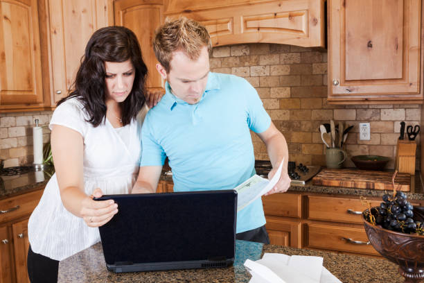 istock Young Couple Paying Bills Online in the Kitchen 965151354