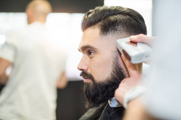 istock Handsome young man getting a haircut profile view. 965164252