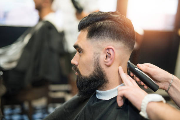 Handsome young man getting a haircut.