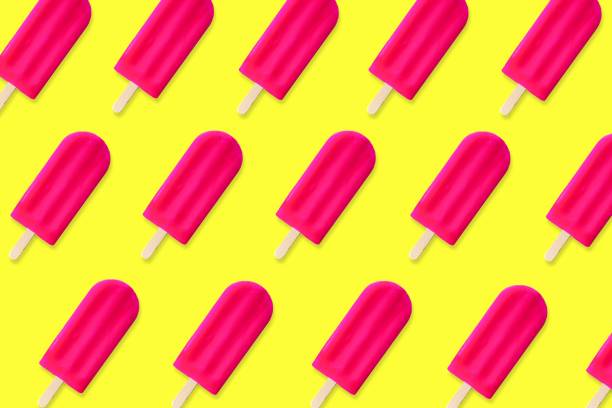 istock Summer pattern of pink popsicles on a yellow background 965187944