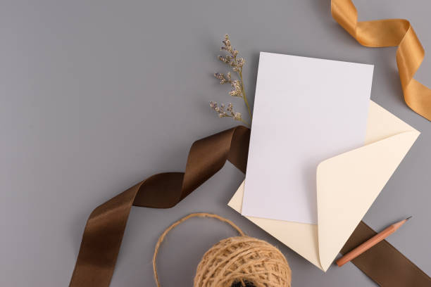 istock A wedding mock up concept. Wedding Invitation, envelopes, cards Papers on grey background with ribbon and decoration. Top view, flat lay, copy space 965210242