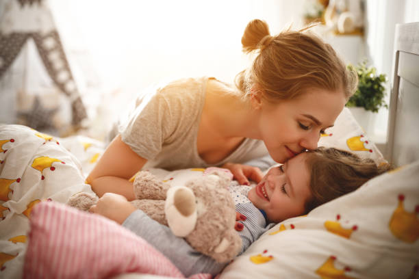 mother wakes her daughter in bed in  morning morning awakening. mother wakes her daughter in bed in morning 8564 stock pictures, royalty-free photos & images