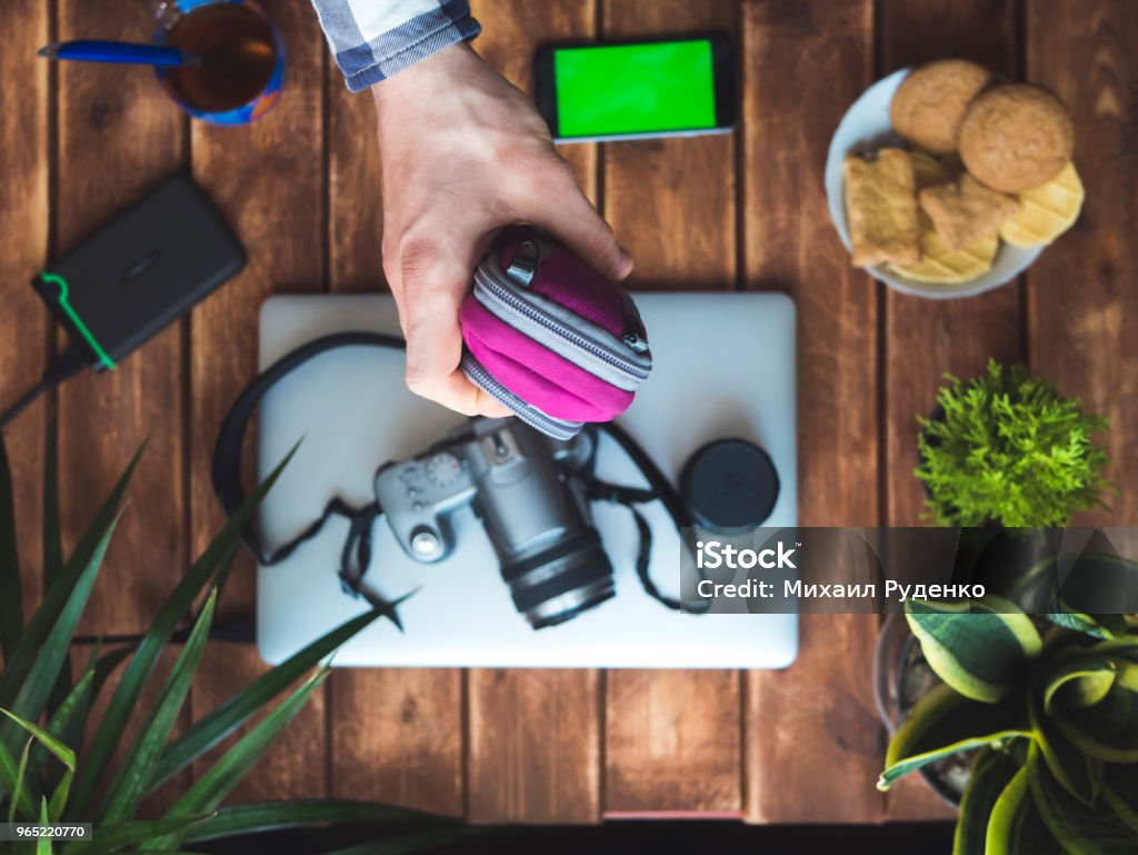 hand holding a protection camera case over wooden table Above Stock Photo