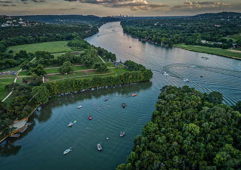 Aerial photo taken over a lake in Austin, Texas featuring boats and the city skyline.