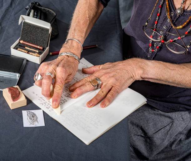 istock Mature woman prepares her notebook for writing and drawing. 965240974