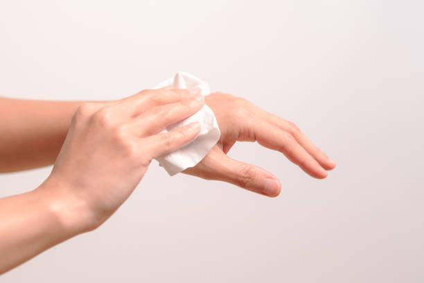 istock Woman cleaning her hands with white soft tissue paper. isolated on a white backgrounds 965243638