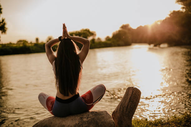 istock Woman doing yoga exercise by the river 965246098