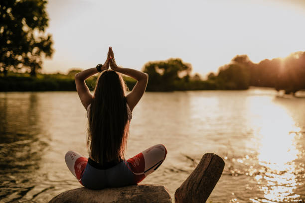 istock Woman doing yoga exercise by the river 965246110