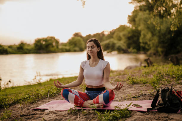 istock Woman doing yoga exercise by the river 965248458