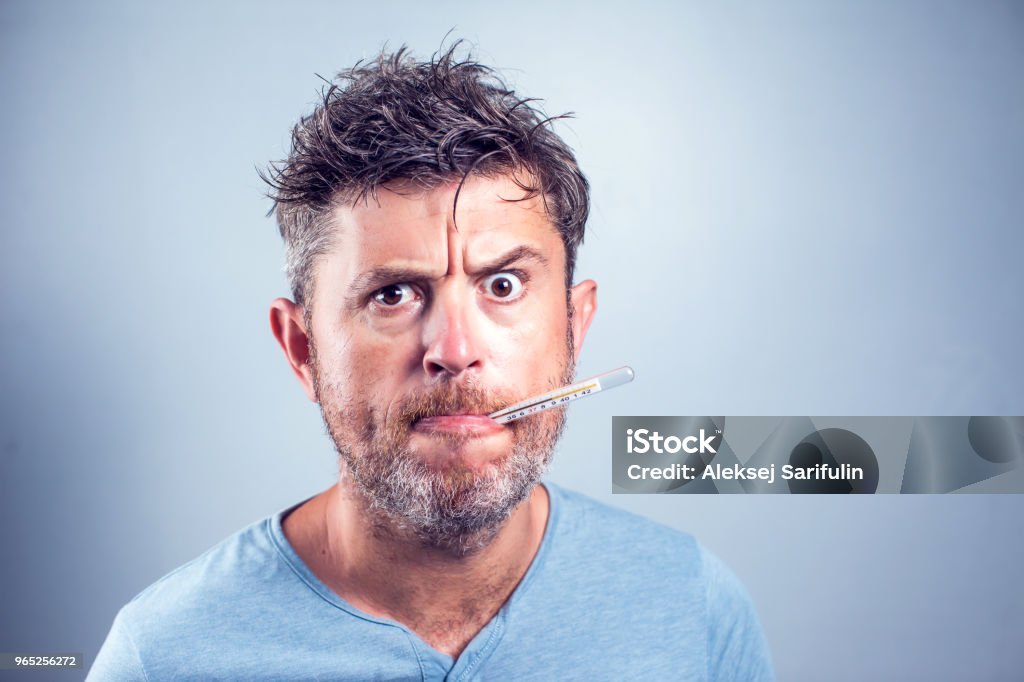 Sick man with thermometer in mouth,looking and worry at thermometer on white background,healthcare concept Adult Stock Photo