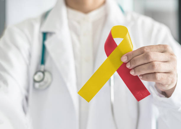 światowy dzień zapalenia wątroby i hiv / hcv współzakażenie świadomości z czerwoną żółtą wstążką w ręce lekarza symboliczny kolor łuku do wspierania pacjenta z chorobą i chorobą wątroby - cancer victim zdjęcia i obrazy z banku zdjęć