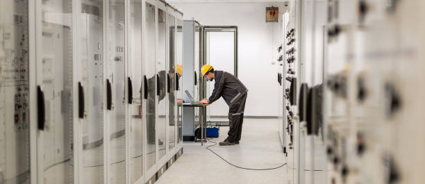 istock Field service engineer inspect relay protection system with laptop comput 965267072