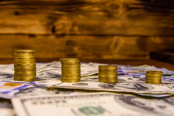 istock Stack of the coins on the one hundred dollar bills 965273184