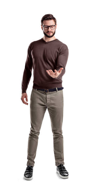 A fashionable man in glasses and casual clothes stands looking at his empty upturned hand as if holding an object A fashionable man in glasses and casual clothes stands looking at his empty upturned hand as if holding an object. Presentation. New product. Holding out sample. male is standing and shows outstretched hand with open palm stock pictures, royalty-free photos & images