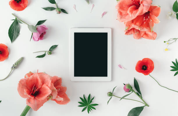 istock Flat lay tablet computer with blank screen on white background with wildflowers, poppy, amaryllis, peonies, top view 965296986