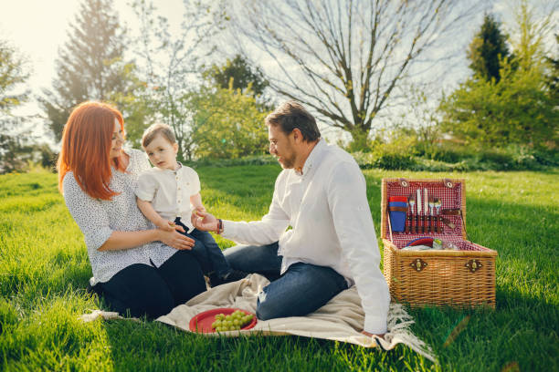 istock cute family sitting in a sunny park 965322468