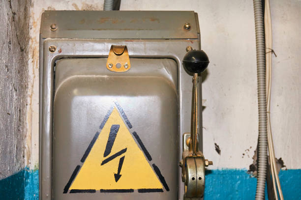 An old electric high-voltage switch with a painted danger sign.